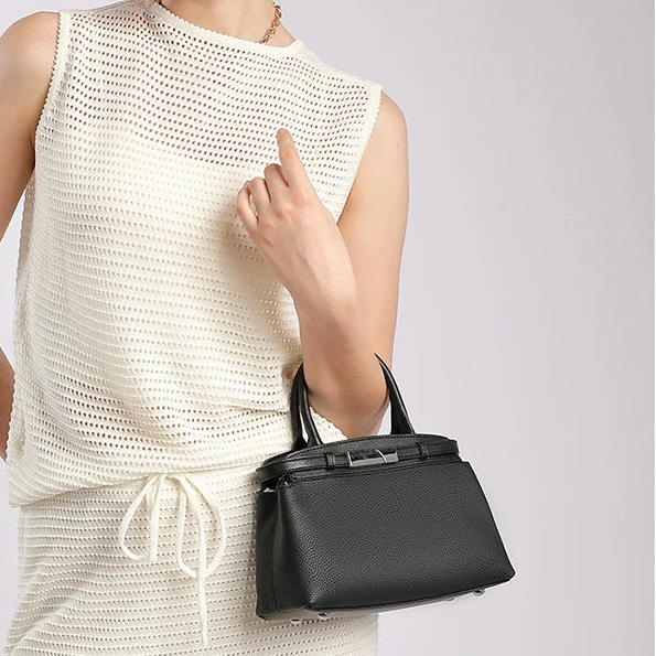 Small square leather bag — flap closure detail in black
