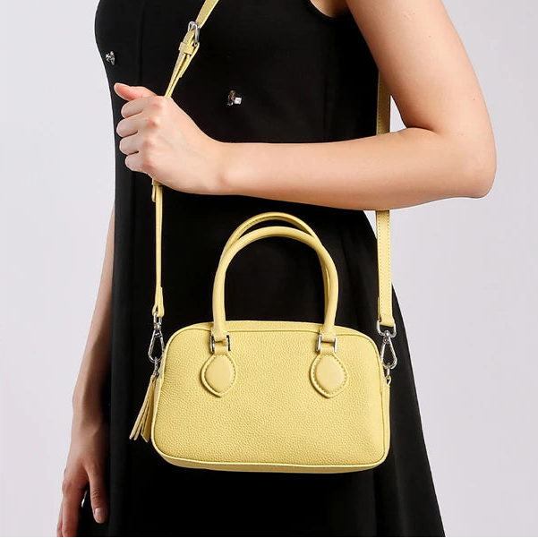 Woman wearing mini genuine leather pillow bag on the shoulder — adjustable strap, relaxed everyday carry