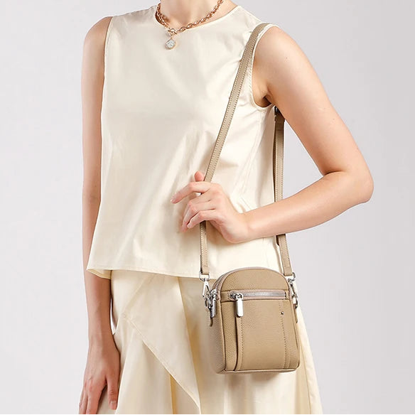 Woman wearing mini genuine leather shoulder bag — adjustable strap worn on the shoulder, everyday casual look