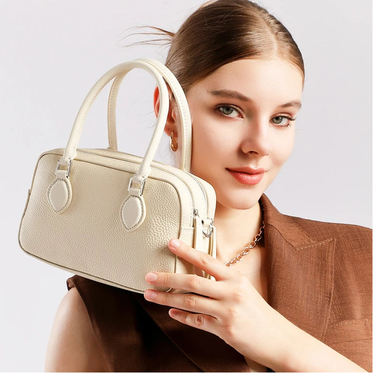 Woman wearing mini genuine leather pillow bag crossbody — Boston silhouette, casual chic everyday style