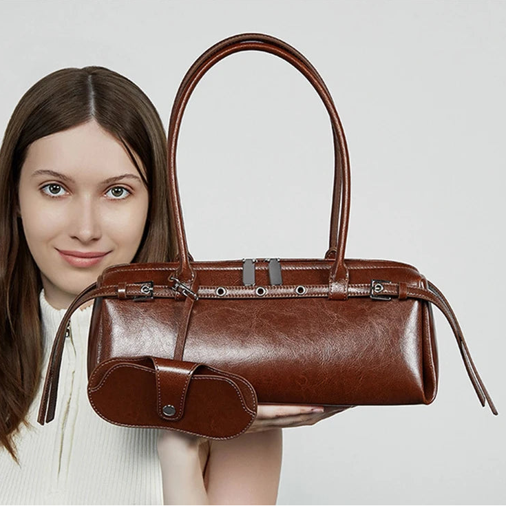 Woman holding retro baguette bag in hand — split leather shoulder bag, casual everyday style